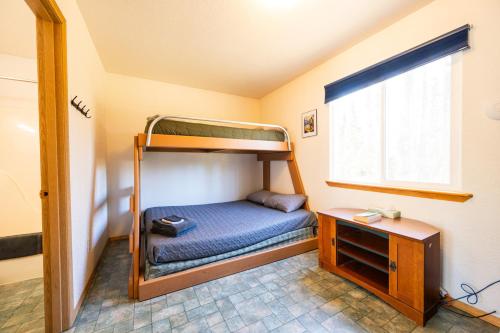 a small room with a bunk bed and a desk at Grayling Getaway, Cabin 1 at Lower Kenai Lodge in Kenai