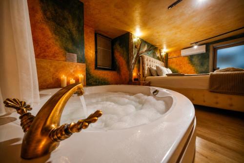 a bathroom with a bath tub with a bed at Cappadocia Divin House in Göreme