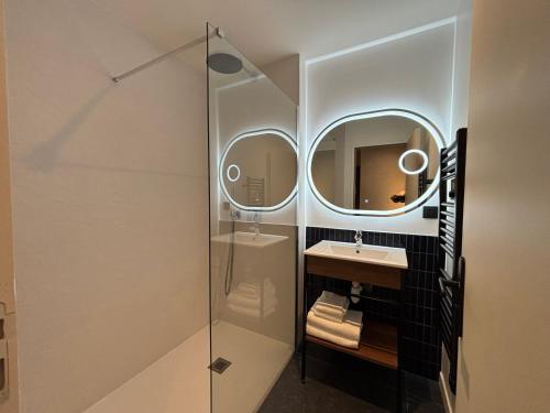 a bathroom with a sink and a mirror at Flore Hôtel & Jardin The Originals Relais in Vichy