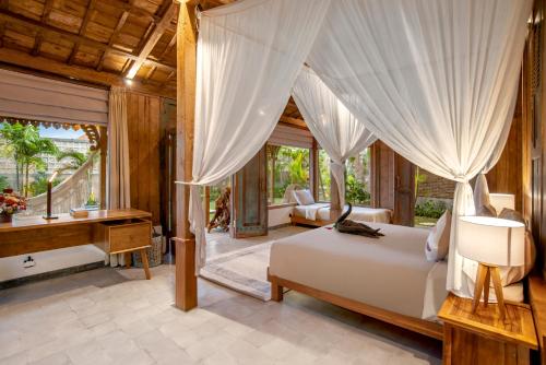 a bedroom with a bed and a desk in a room at Casa Sepang in Munggu