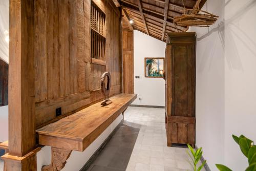 a hallway with wooden walls and a wooden bench at Casa Sepang in Munggu