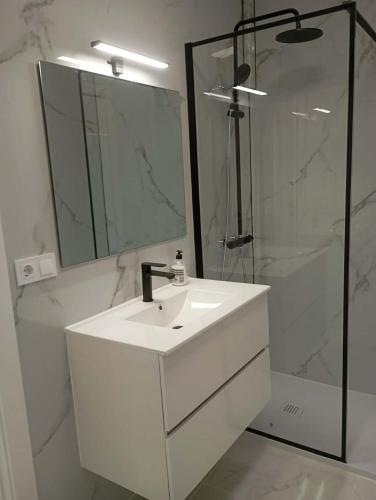 a white bathroom with a sink and a shower at Casa de la Luz del Sol in Mojácar