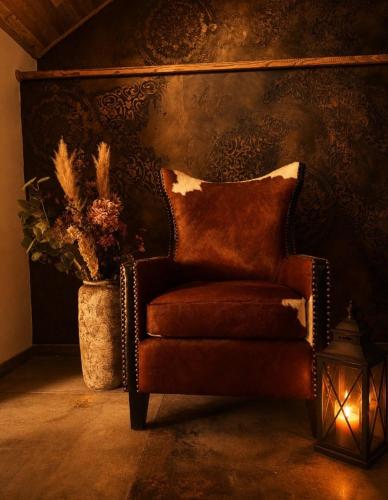 a brown chair sitting in a room with a vase at Rezidence U Kapličky - stylové ubytování & privátní wellness - Adults Only in Uničov