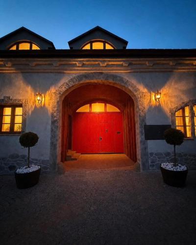 a red door of a building with two trees in front at Rezidence U Kapličky - stylové ubytování & privátní wellness - Adults Only in Uničov