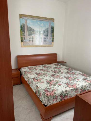 a bedroom with a bed with a floral comforter at Happy Oasi in Lido Adriano