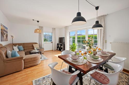a living room with a dining table and chairs at Zaunkönigin in Norden