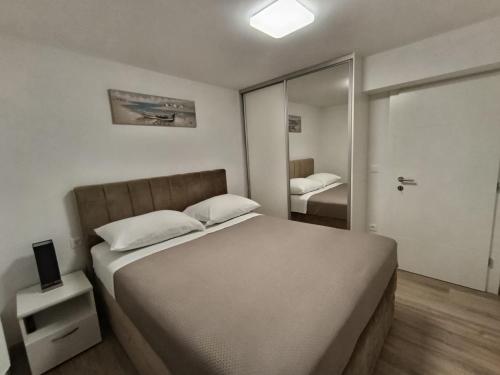 a bedroom with a large bed and a mirror at Apartmani Srdarović in Drage