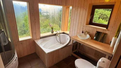 a bathroom with a tub and a sink and a toilet at Ostaya - Mountain Cottage in Obidza