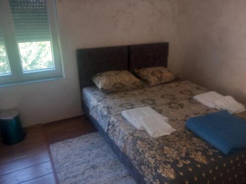a bed with two pillows on it in a room at Apartman Selišta in Danilovgrad