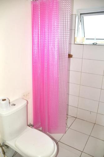 a pink shower curtain in a bathroom with a toilet at MO Buxton Lux Apartment- Mombasa CBD 70 in Frere Town