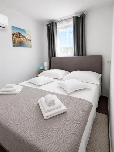 a bedroom with a large bed with two towels on it at Room Jakov in Šibenik