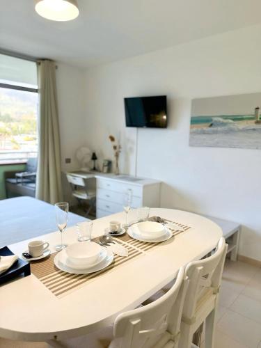 a dining room table with plates and wine glasses at Edificio Las Marañuelas, Puerto La Cruz, Islas Canarias Tenerife in Puerto de la Cruz