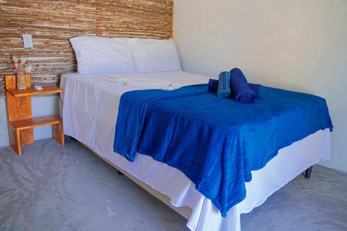 a bedroom with a bed with a blue blanket on it at Pousada vila jaguar - arpoador in Tutóia
