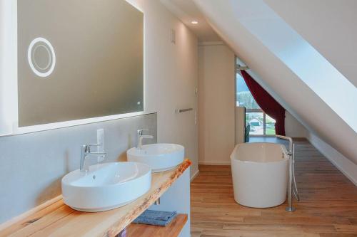 a bathroom with two sinks and a staircase at Penthaus Aldebaran by Salzkammergood Living in Tauplitz