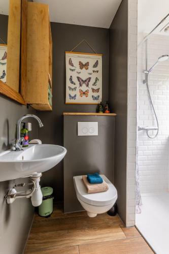 a bathroom with a sink and a toilet and a shower at Appartement de Tuinkamer in Kampen
