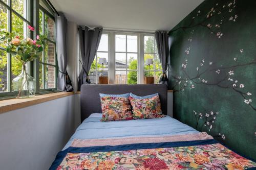 a bedroom with a bed with a green wall at Appartement de Tuinkamer in Kampen