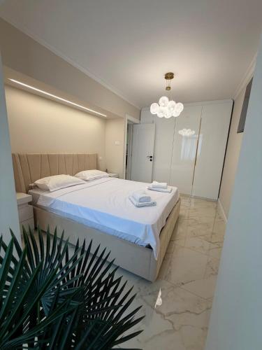 a bedroom with a large bed and a chandelier at Luma Apartment in Tecuci