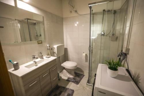 a bathroom with a toilet and a shower and a sink at White Duomo Rooms in SantʼAgata di Militello