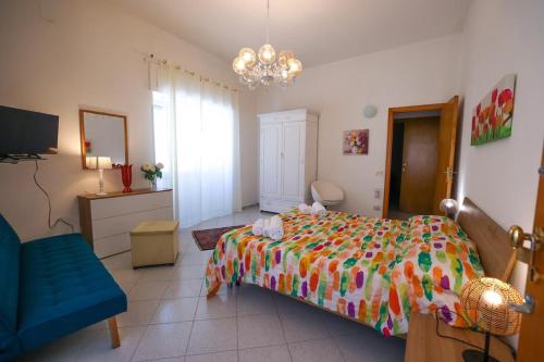 a bedroom with a bed and a blue chair at White Duomo Rooms in SantʼAgata di Militello