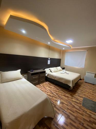 a hotel room with two beds and a white board at Hotel Altos de la Puna in San Antonio de los Cobres