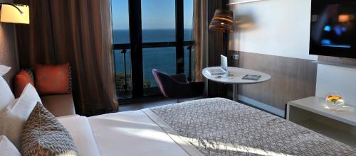 a hotel room with a bed and a view of the ocean at Pullman Dakar Teranga in Dakar