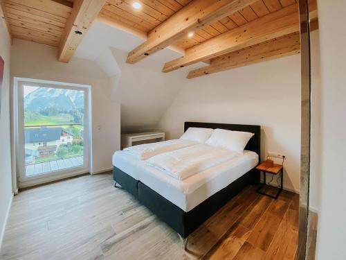 a bedroom with a bed and a large window at Penthaus Aldebaran by Salzkammergood Living in Tauplitz
