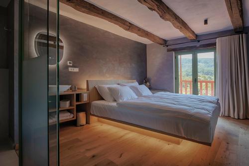 a bedroom with a bed and a glass wall at Posestvo Pri žabi in Štanjel