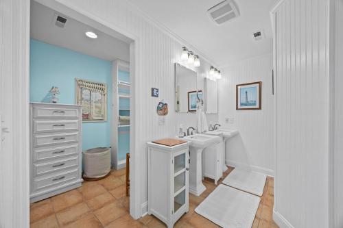 a white bathroom with two sinks and a mirror at Luxury Waterfront & Oceanfront Beach Paradise in North Topsail Beach