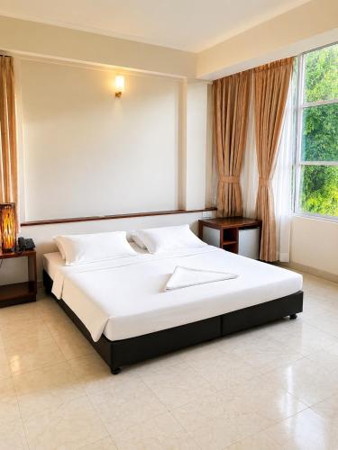 a bedroom with a large white bed and a window at Off Day Inn in Male City