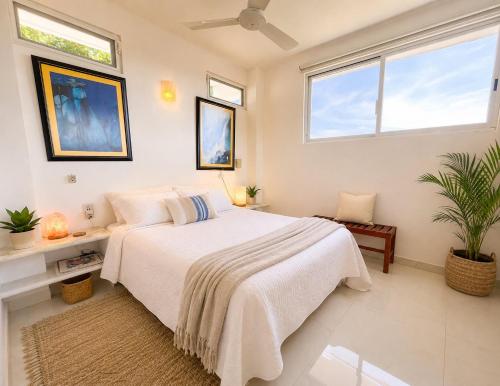 a white bedroom with a bed and two windows at Valentina Salchi Bay virgin beaches fast internet in Cuatunalco