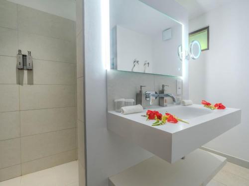 a bathroom with a sink with red flowers on it at Manava Beach Resort & Spa Moorea in Maharepa