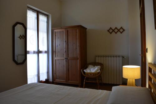 a bedroom with a bed and a cabinet and a lamp at B&B Tramonti sull'Adriatico in Muggia