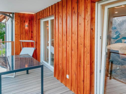 a glass table on a deck with a chair at Apartment Gemini by Salzkammergood Living in Tauplitz