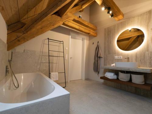 a large bathroom with a large tub and a mirror at Fuxbau Allgäu in Argenbühl