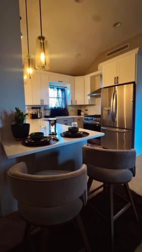a kitchen with a refrigerator and two bar stools at La Suite de Antonio Shared Property PRIVATE stay NYC 18mins in North Bergen