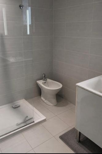 a bathroom with a toilet and a tub and a sink at Maison CÔTE OUEST in Labenne
