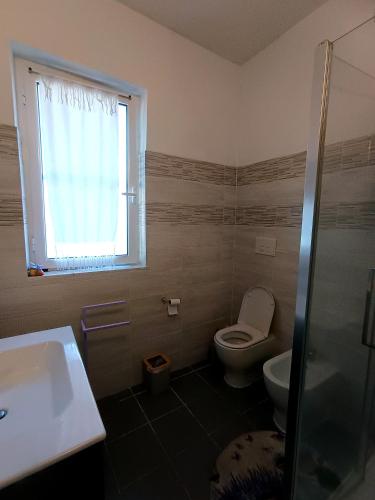 a bathroom with a toilet and a sink and a window at Timo e Lavanda in Albenga