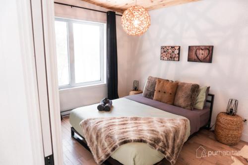 a bedroom with a bed and a window at Pur Nature et Spa Owl's Head in Mansonville