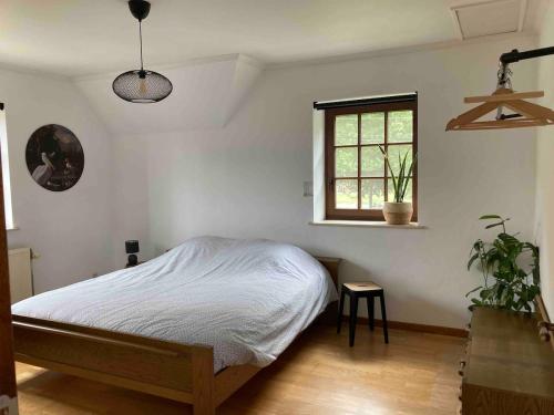 a white bedroom with a bed and a window at Wahwo Baki in Wachtebeke