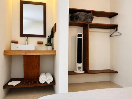 a bathroom with a sink and a mirror on a wall at Meson de Valle Hotel in Valle de Bravo