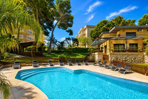 a swimming pool with lounge chairs and a house at New Play Lake Villa in Salou