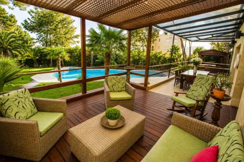 a patio with chairs and a table and a pool at New Play Lake Villa in Salou