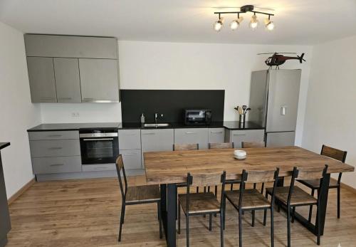a kitchen with a wooden dining table and chairs at L'aparté Roussat in Langres