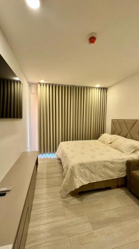 a bedroom with a bed and a window with curtains at Apartaestudio tipo loft cerca al mar in Santa Marta
