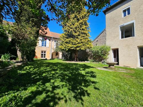 a grassy yard with a bench in front of a building at L'aparté Roussat in Langres