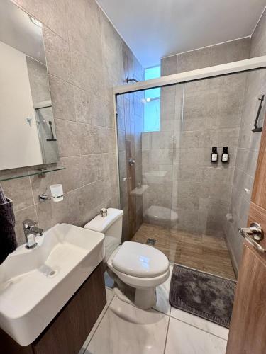 a bathroom with a toilet and a sink and a shower at Habitaciones cómodas en Coto Galeana Guadalajara in Guadalajara