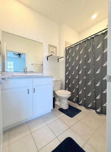 a bathroom with a toilet and a sink and a mirror at Casa Lux in Florida City