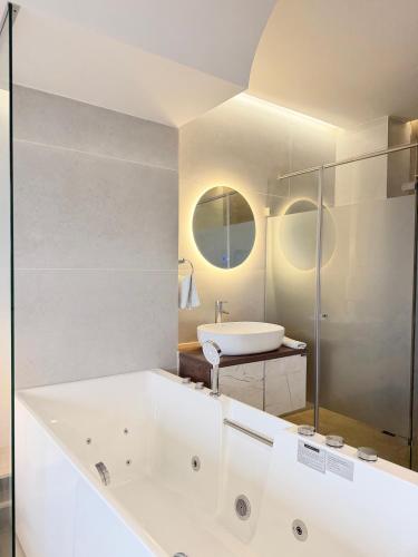 a white bathroom with a tub and a sink at Hotel Balcones in La Hormiga