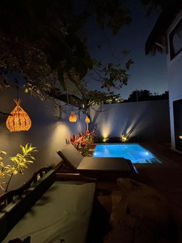 a backyard with a swimming pool at night at Zenhousepipa in Pipa