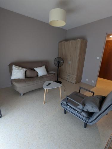 a living room with a couch and a table at Studio Issoire pour 2 adultes et 1 enfant in Issoire